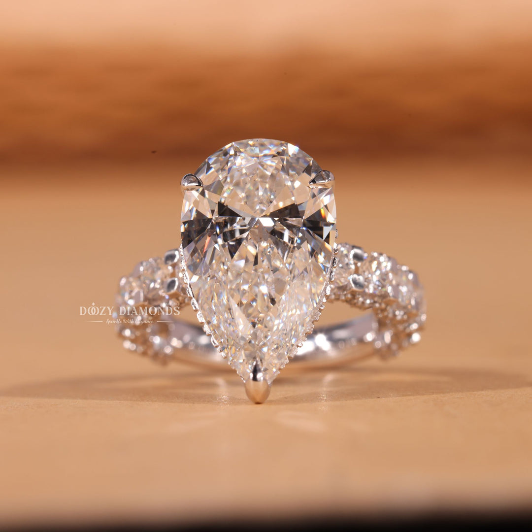 Close-up of pear cut center diamond in pave engagement ring