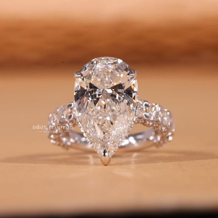Close-up of pear cut center diamond in pave engagement ring