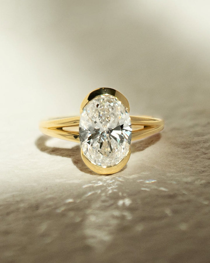 Oval bezel engagement ring finished in polished solid gold