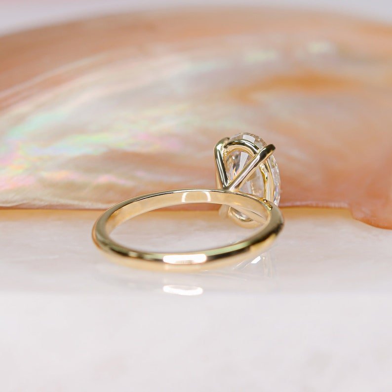 Lifestyle shot of oval solitaire diamond ring on hand