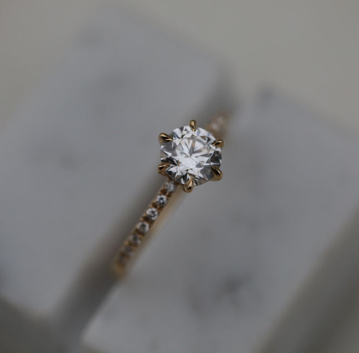 Detailed close-up of round solitaire diamond engagement ring