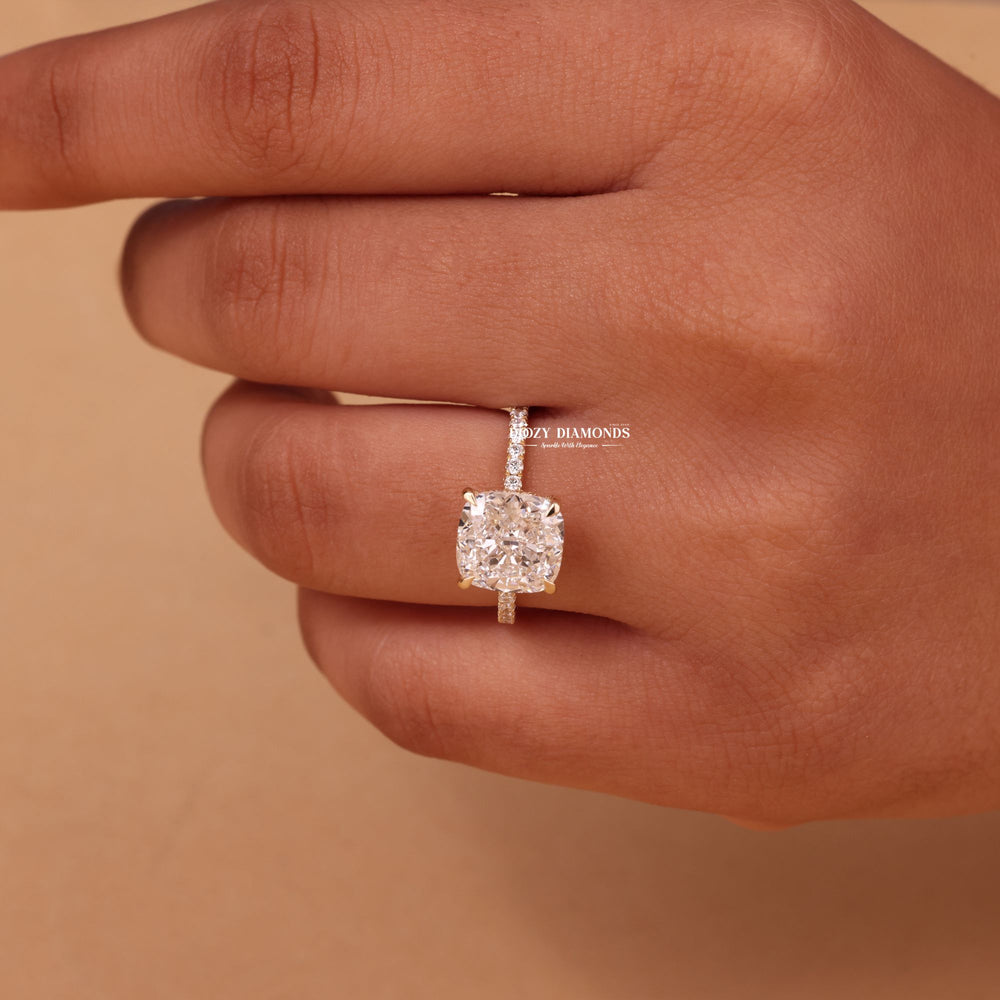 Cushion hidden halo engagement ring shown on hand for true-to-life sizing