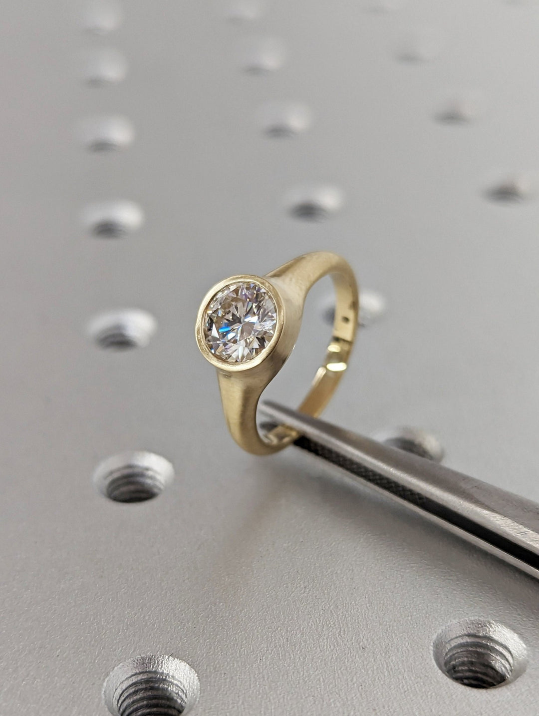 Macro shot of round cut diamond facets in bezel ring setting