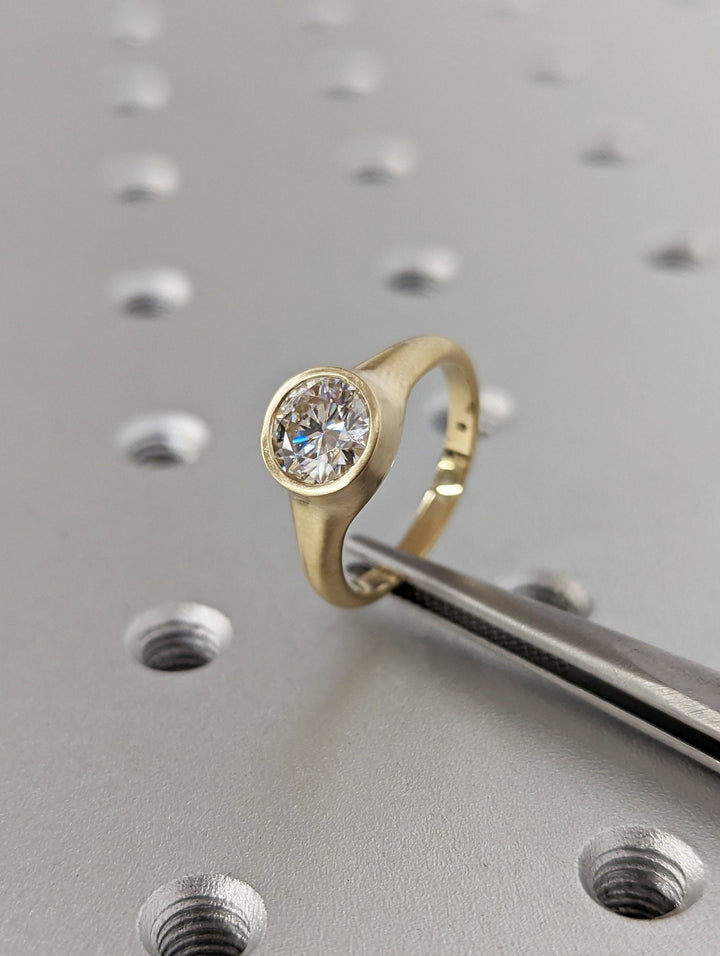 Macro shot of round cut diamond facets in bezel ring setting