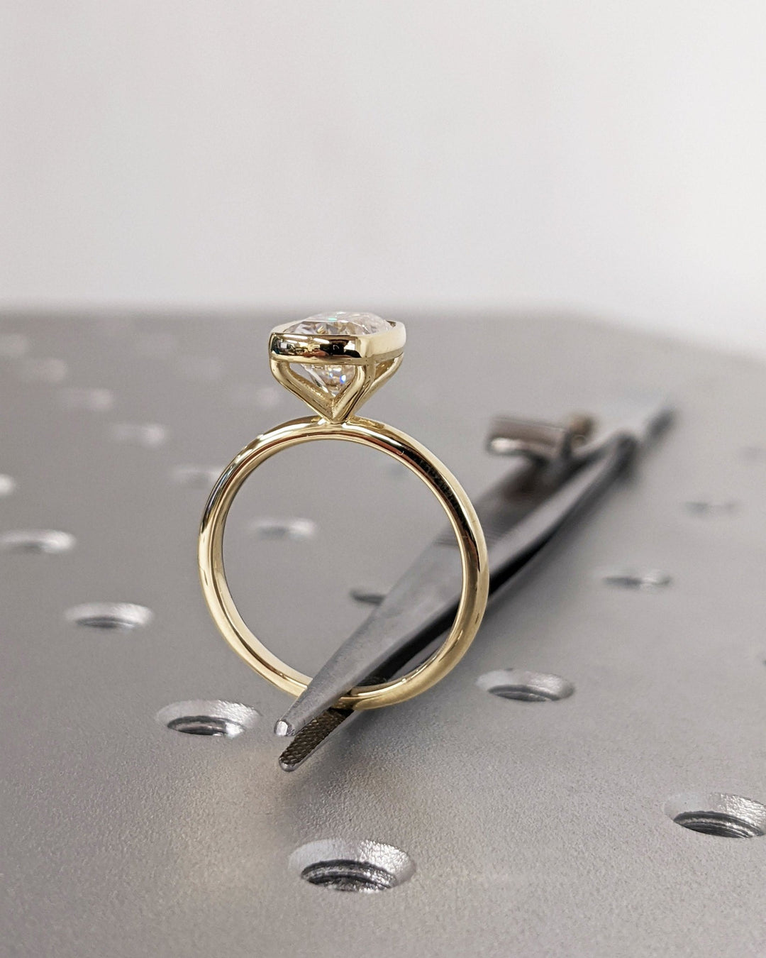 Cushion bezel engagement ring shown on hand for true-to-life sizing