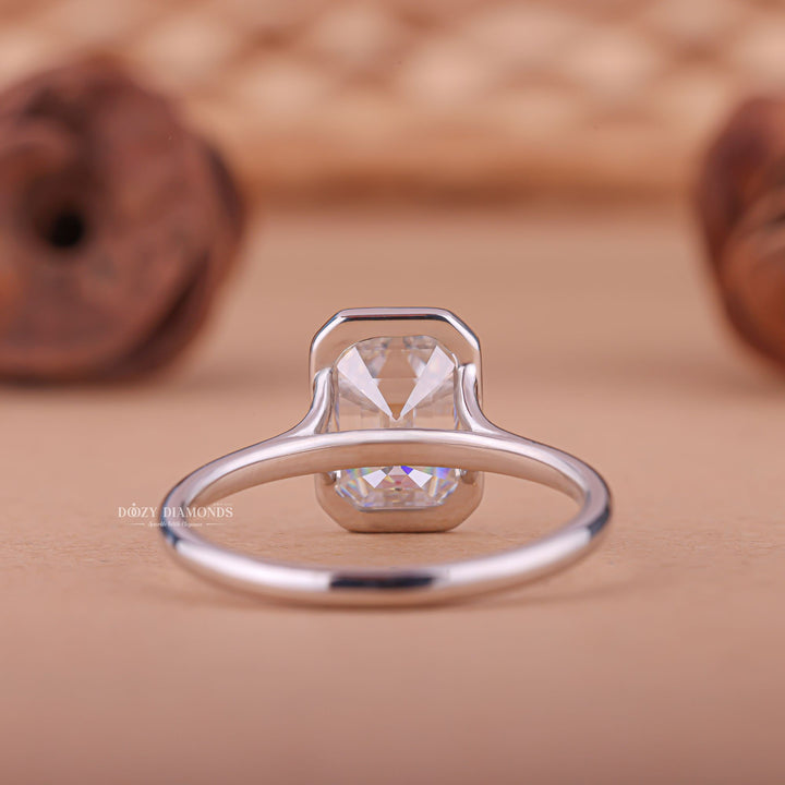Emerald bezel engagement ring shown on hand for true-to-life sizing