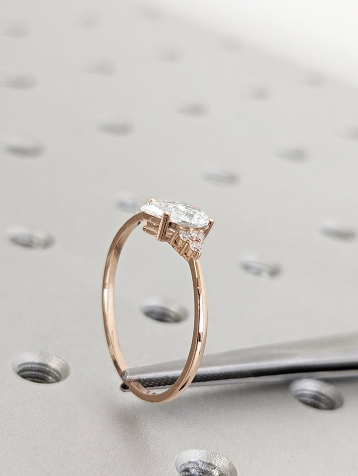 Pear cluster engagement ring shown on hand for true-to-life sizing