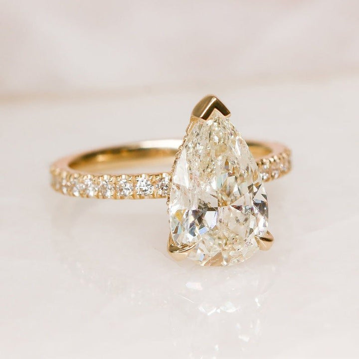 Detailed close-up of pear hidden halo diamond engagement ring
