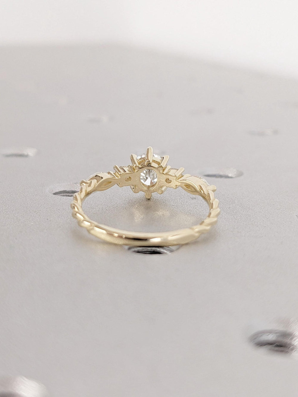 Round cluster engagement ring photographed in natural light