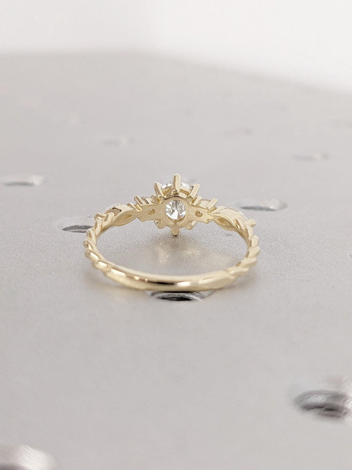 Round cluster engagement ring photographed in natural light