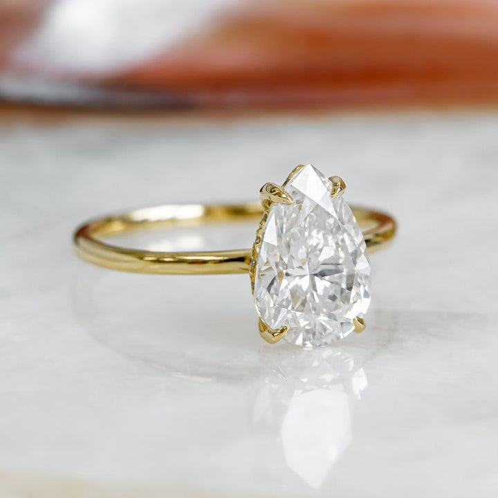 Pear hidden halo ring set with an IGI graded diamond