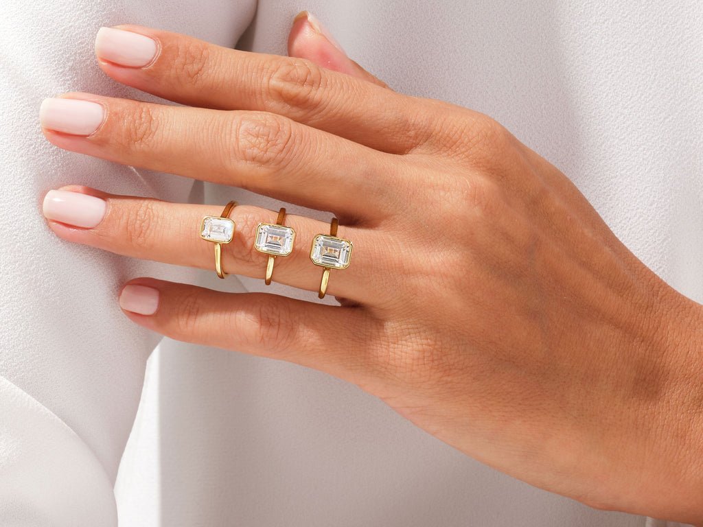 Close-up of emerald cut center diamond in bezel engagement ring