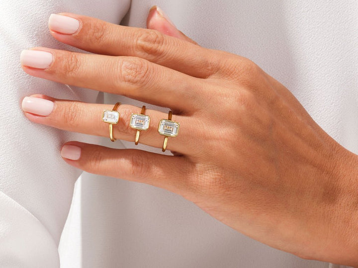 Close-up of emerald cut center diamond in bezel engagement ring
