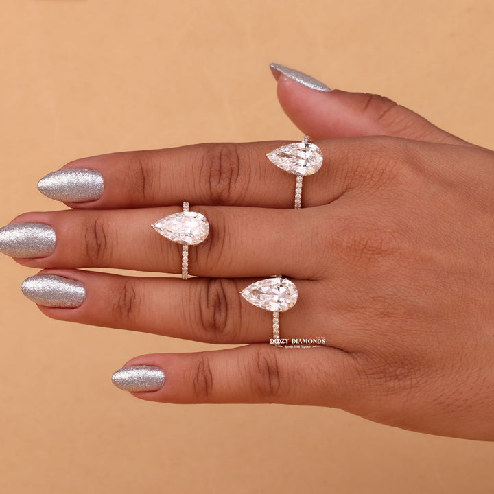 Pear hidden halo engagement ring shown on hand for true-to-life sizing