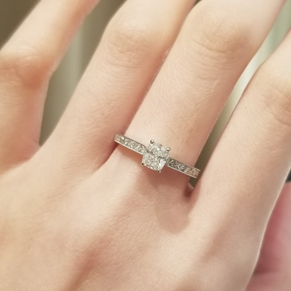 Cushion cut engagement ring shown with authenticity certificate