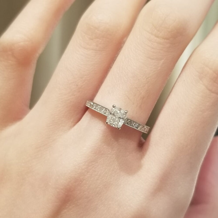 Cushion cut engagement ring shown with authenticity certificate