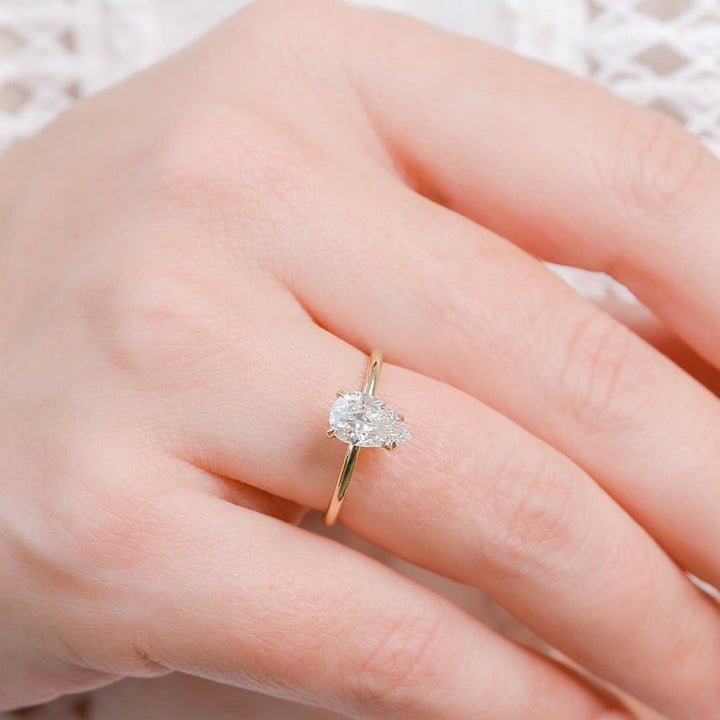 Pear hidden halo engagement ring offered in gold and platinum