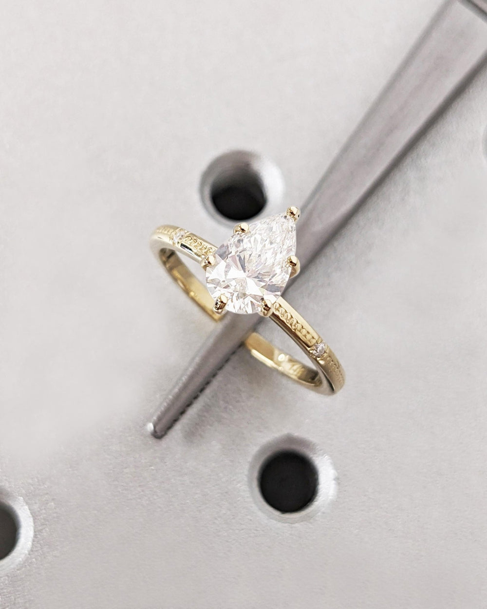 Lifestyle shot of pear solitaire diamond ring on hand