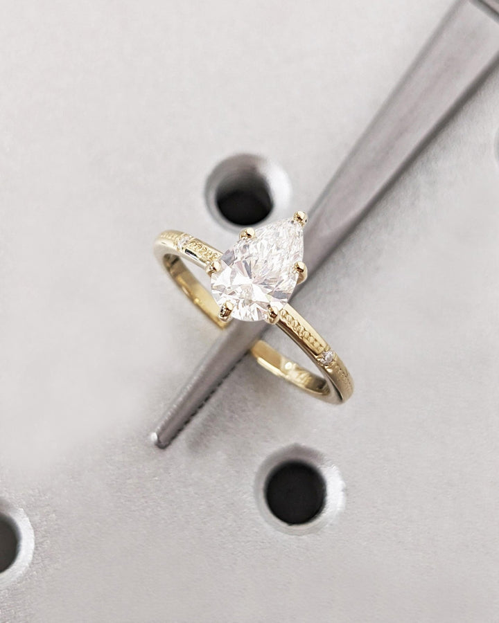 Lifestyle shot of pear solitaire diamond ring on hand