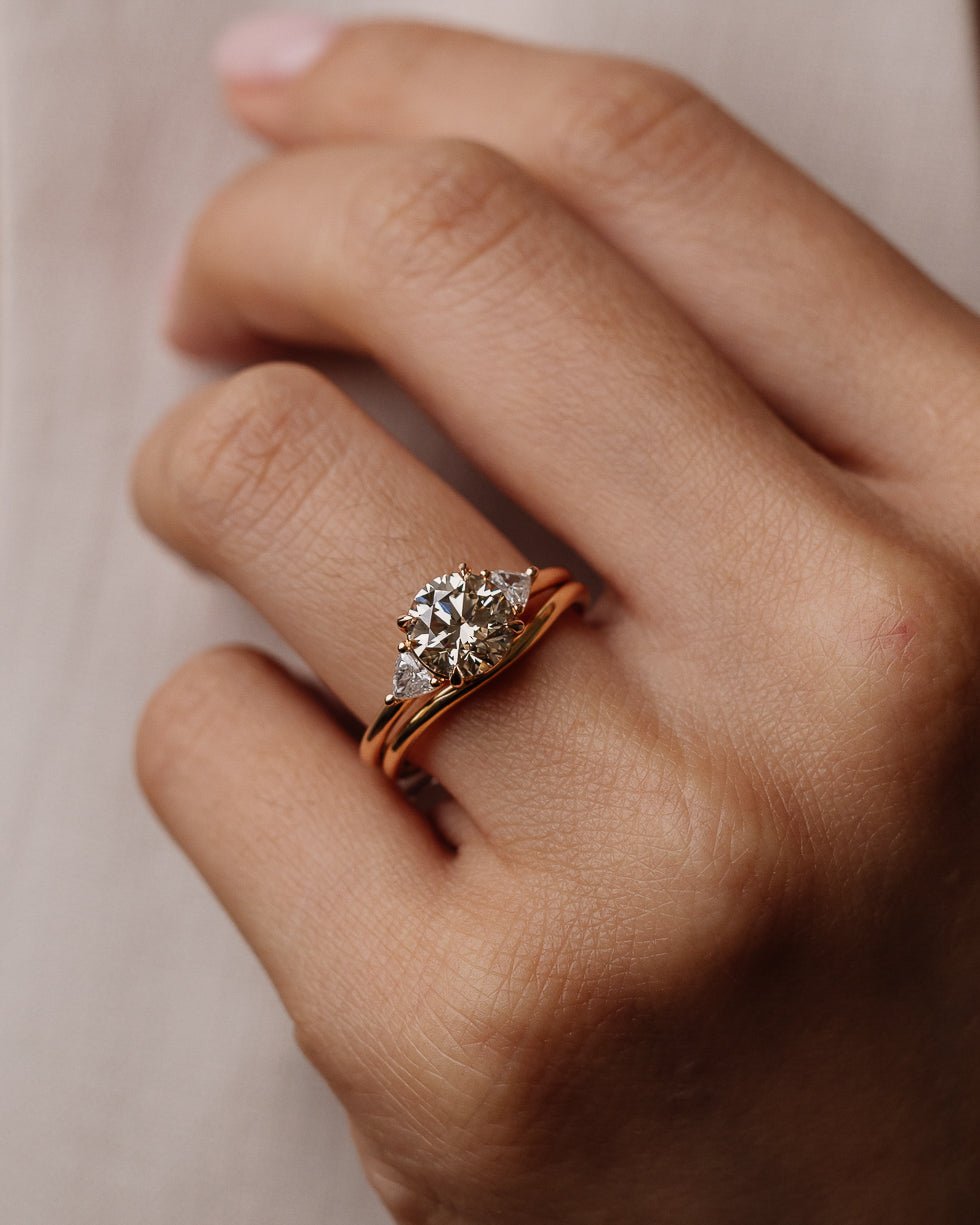Round three stone engagement ring photographed in natural light