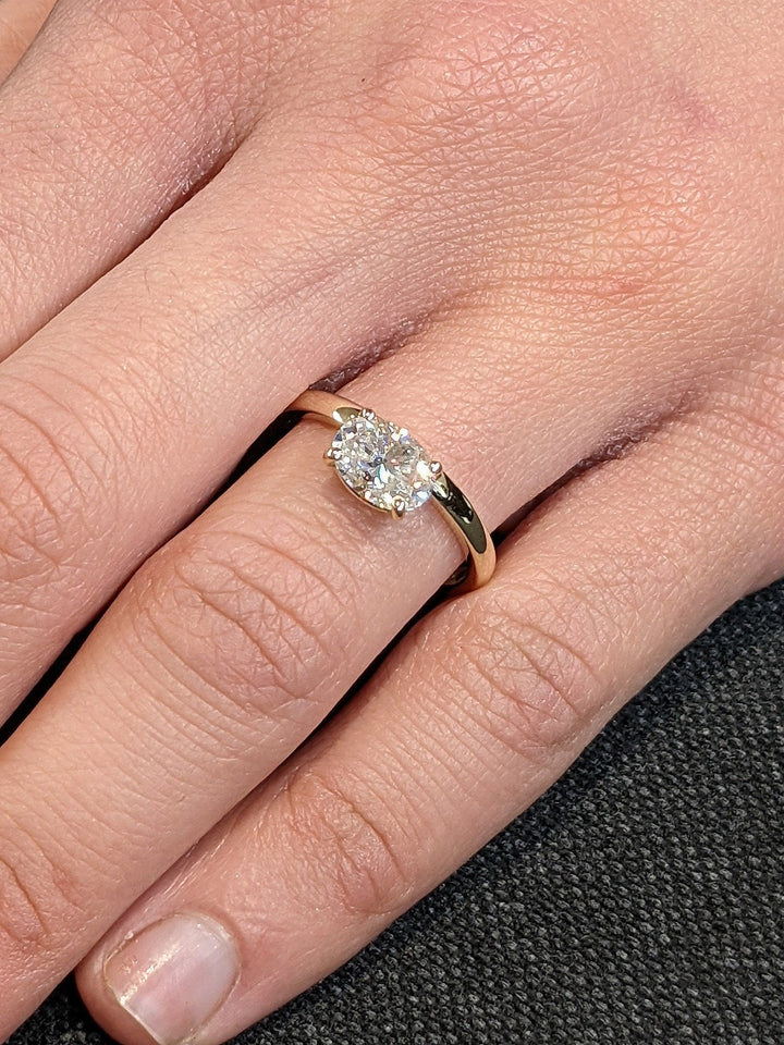 Angled view of oval cut diamond in east west setting