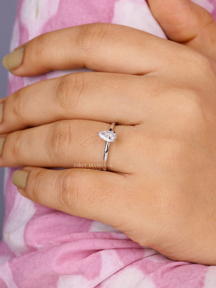 Pear solitaire engagement ring shown on hand for true-to-life sizing