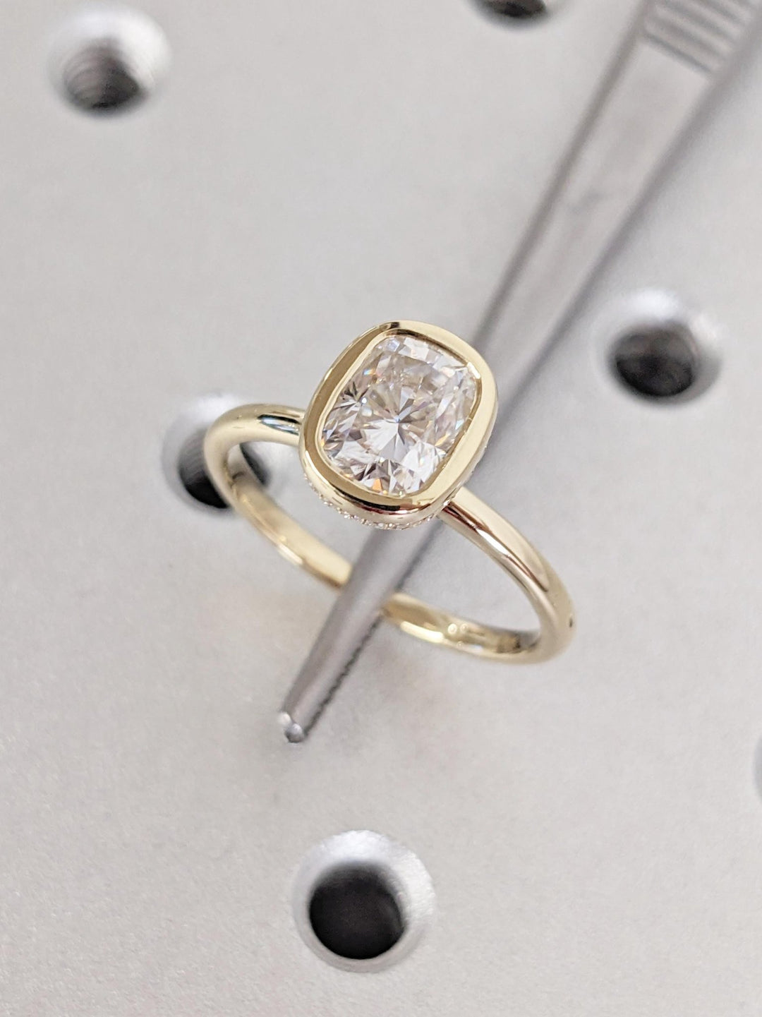 Macro shot of cushion cut diamond facets in hidden halo ring setting