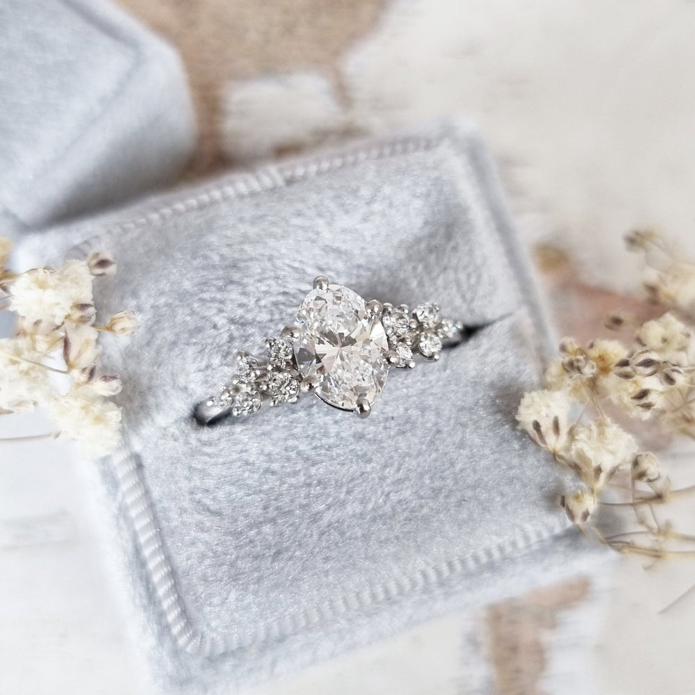 Unboxing view of oval cut cluster diamond engagement ring