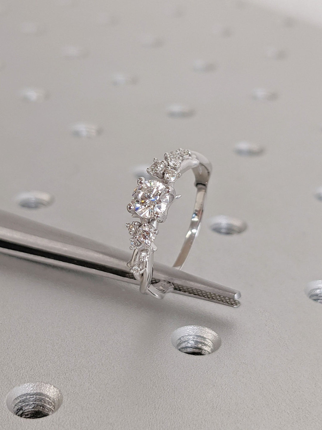 Round cluster engagement ring photographed in natural light