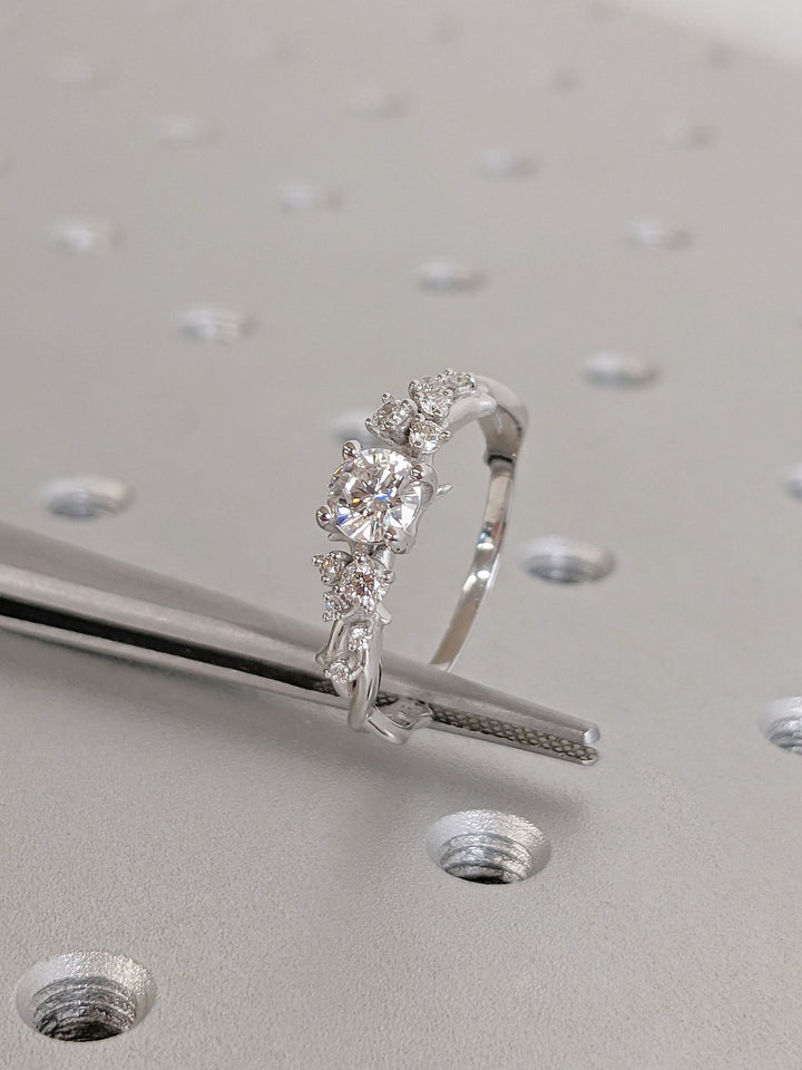 Round cluster engagement ring photographed in natural light