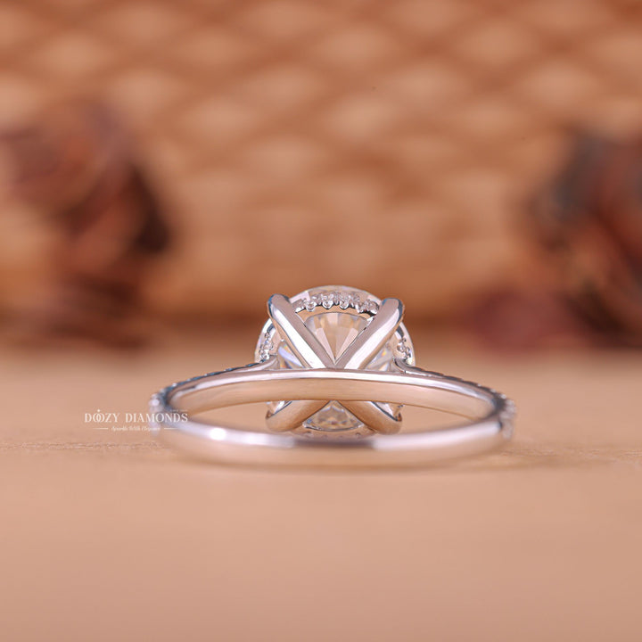 Round hidden halo engagement ring shown on hand for true-to-life sizing
