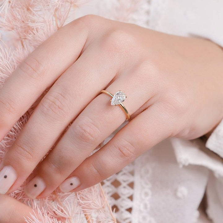 Pear hidden halo diamond engagement ring available in multiple metals