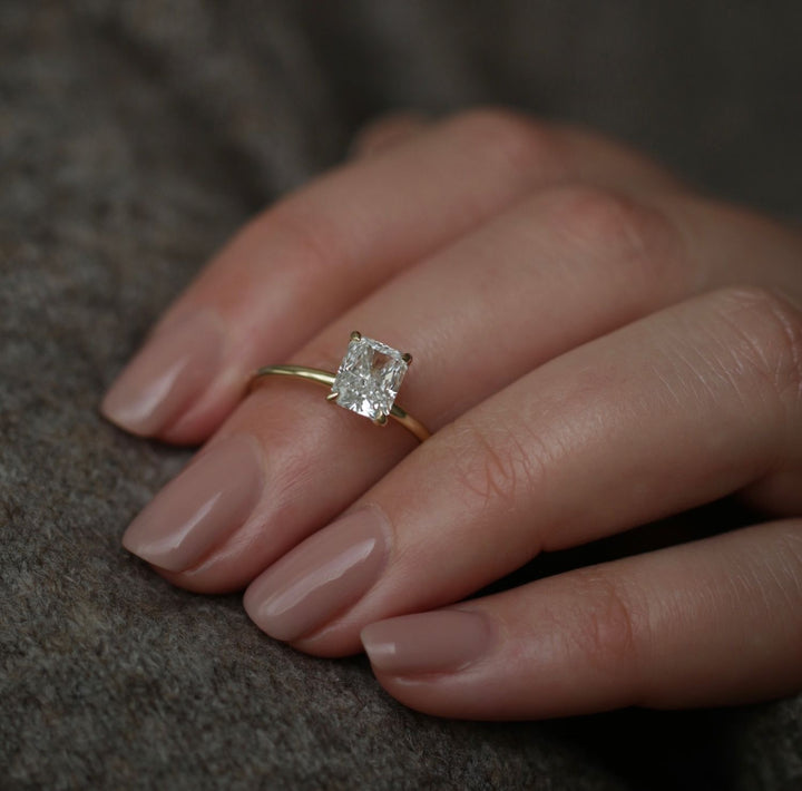 Radiant solitaire engagement ring photographed in natural light