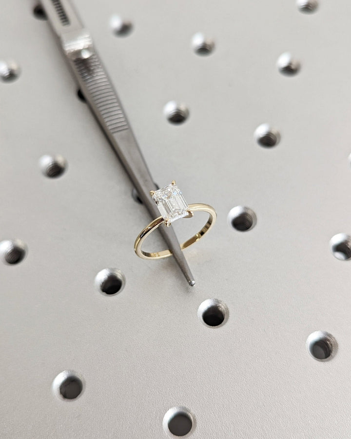 Emerald solitaire engagement ring shown on hand for true-to-life sizing