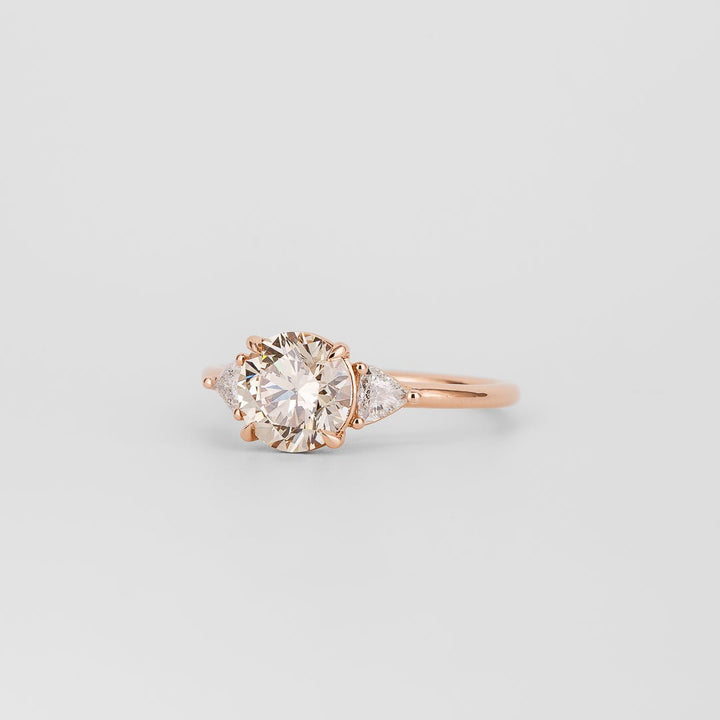 Round three stone diamond ring displayed on jewelry stand