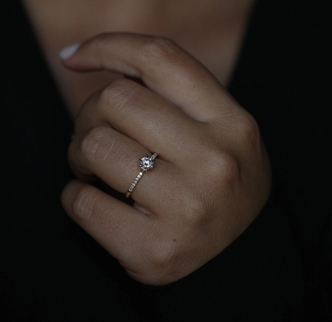 Round solitaire diamond ring displayed on jewelry stand