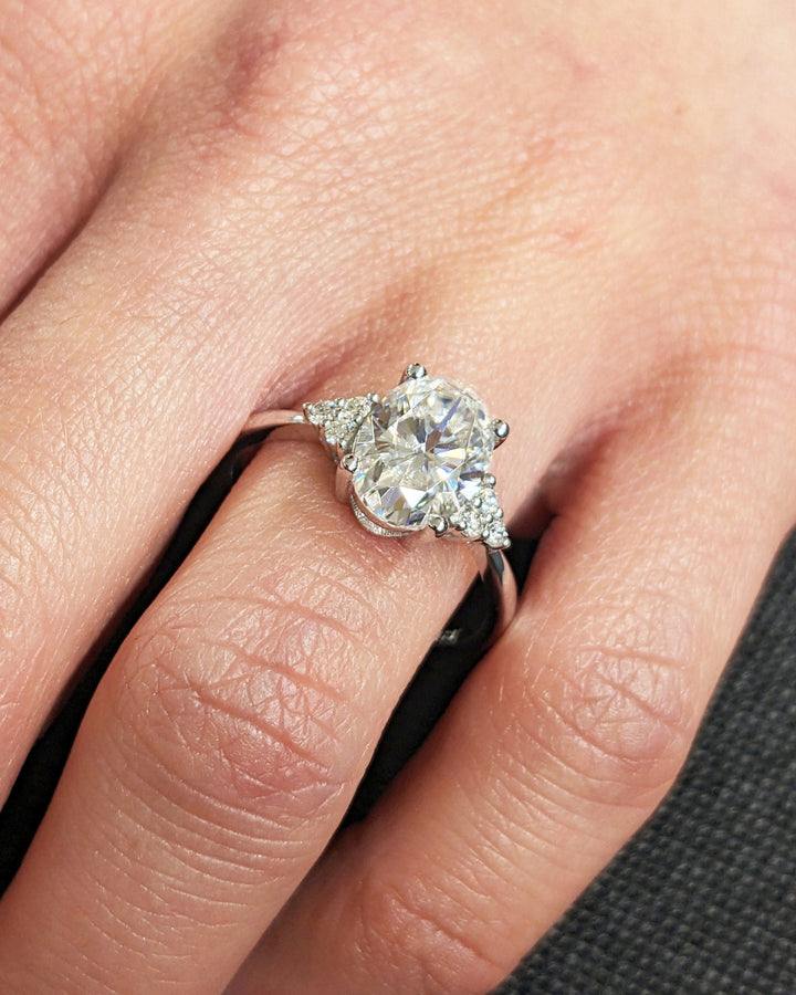 Close-up of oval cut center diamond in cluster engagement ring