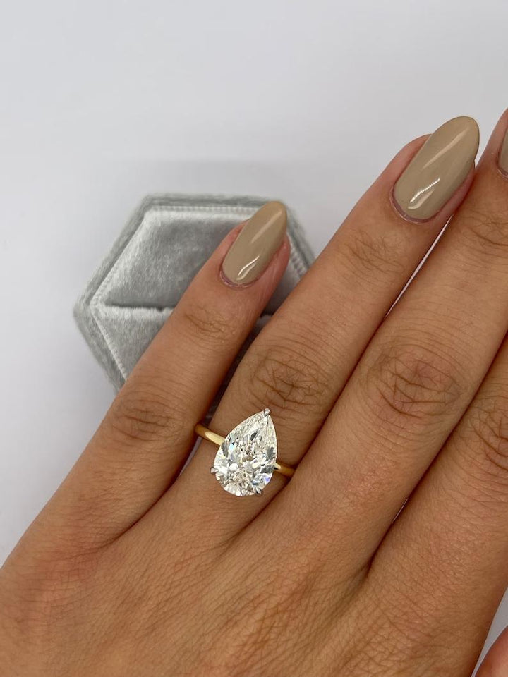 Pear solitaire diamond ring displayed on jewelry stand