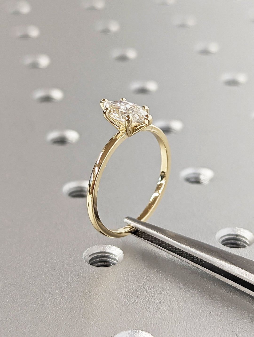 Marquise solitaire engagement ring shown on hand for true-to-life sizing
