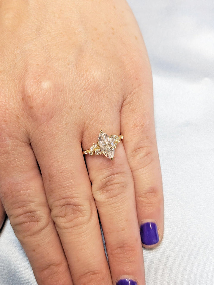 Close-up of marquise cut center diamond in cluster engagement ring