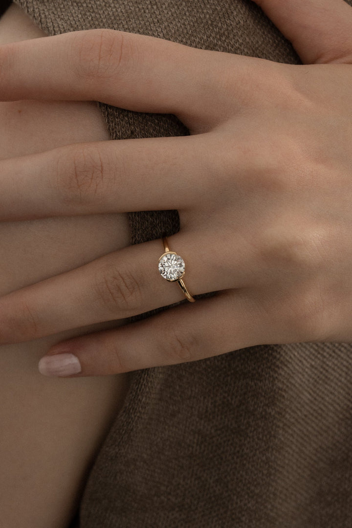 Round bezel engagement ring close-up showing high clarity diamond clarity