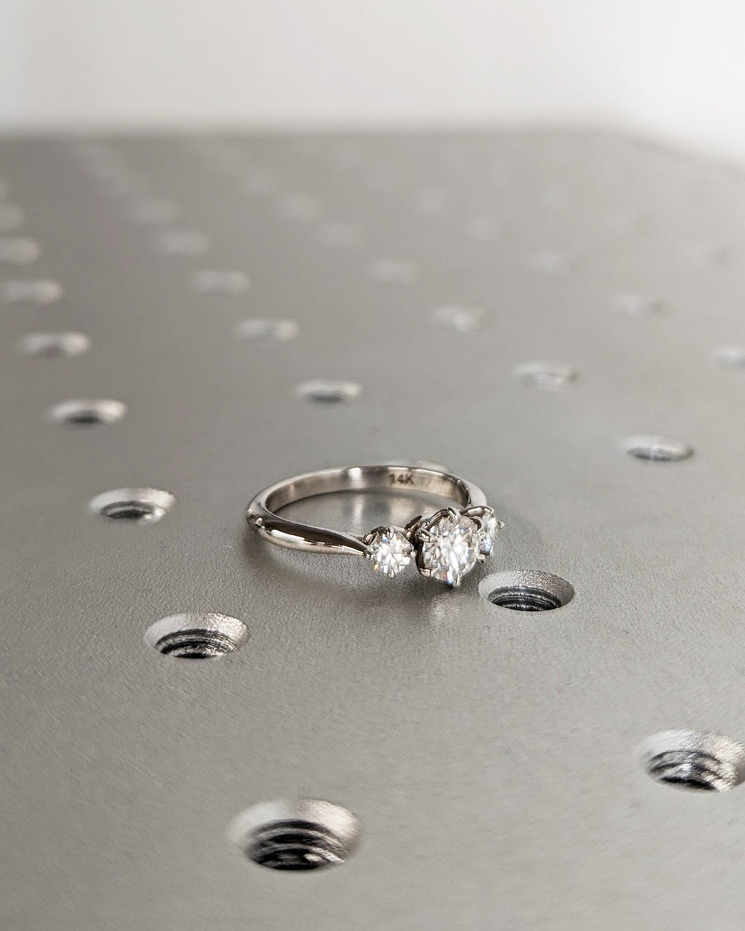Angled view of round cut diamond in three stone setting