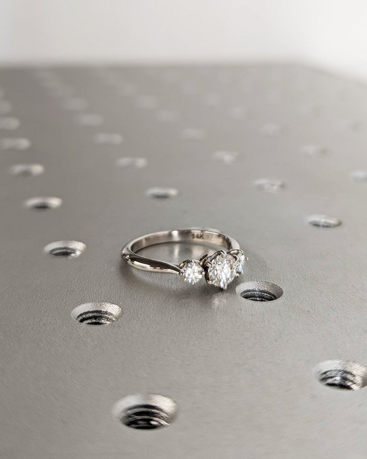 Angled view of round cut diamond in three stone setting