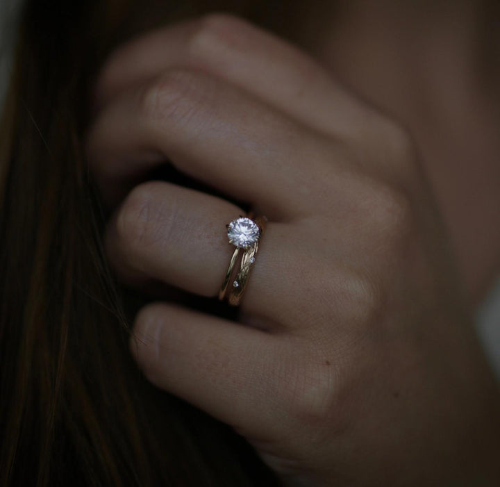 Round solitaire engagement ring photographed in natural light