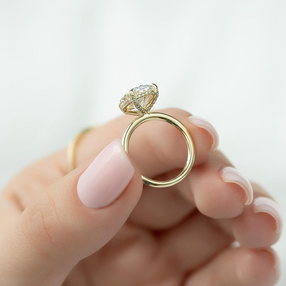 Certified oval cut diamond featured in hidden halo engagement ring