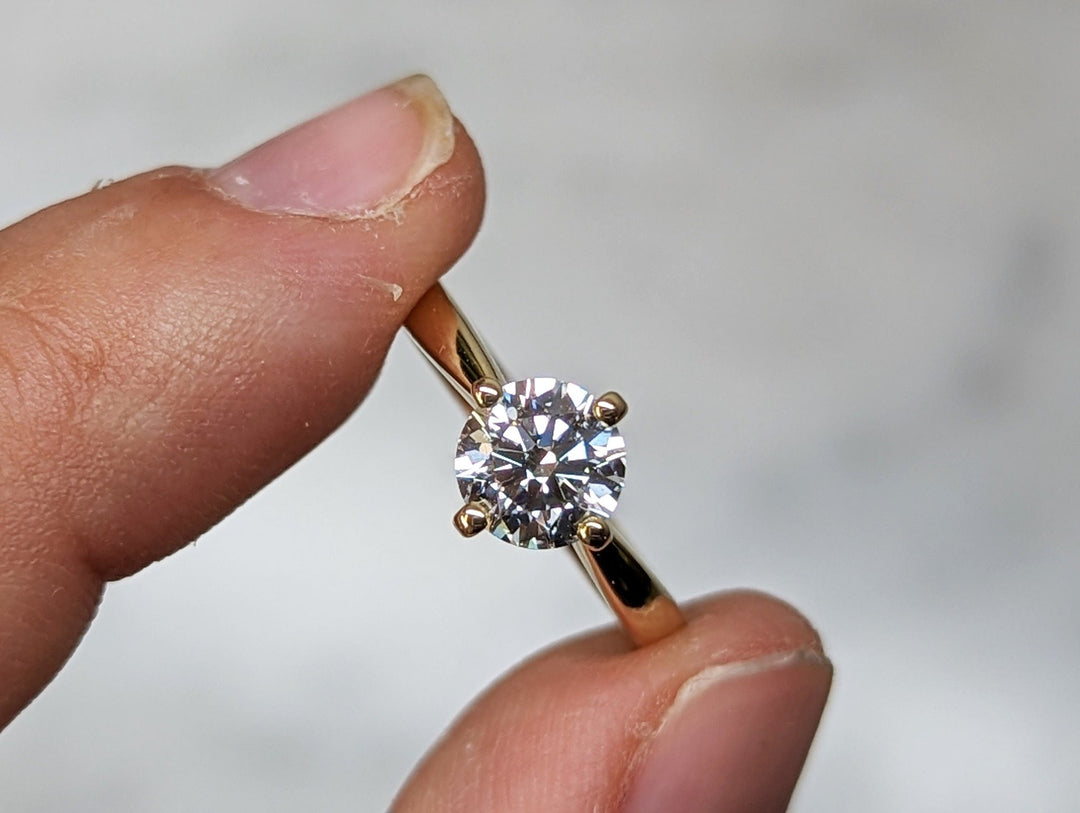 Round solitaire engagement ring close-up highlighting diamond sparkle