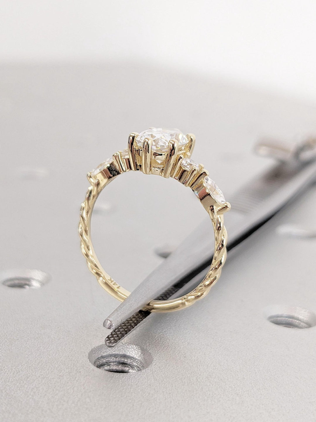 Oval cluster engagement ring shown on hand for true-to-life sizing