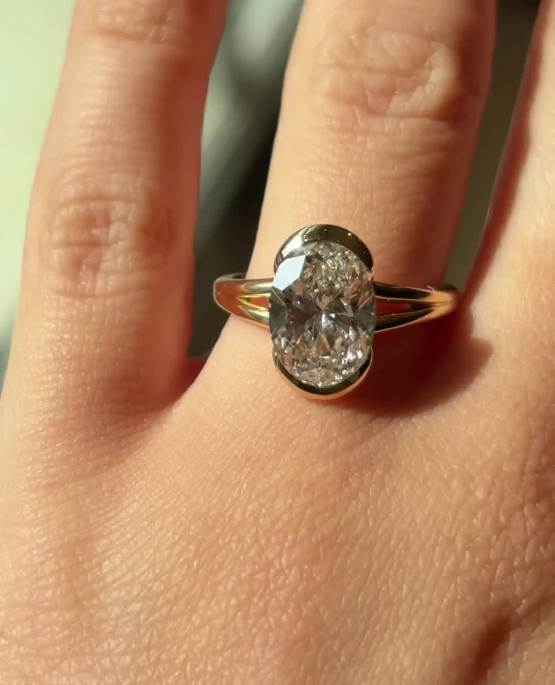 Oval bezel engagement ring photographed in natural light