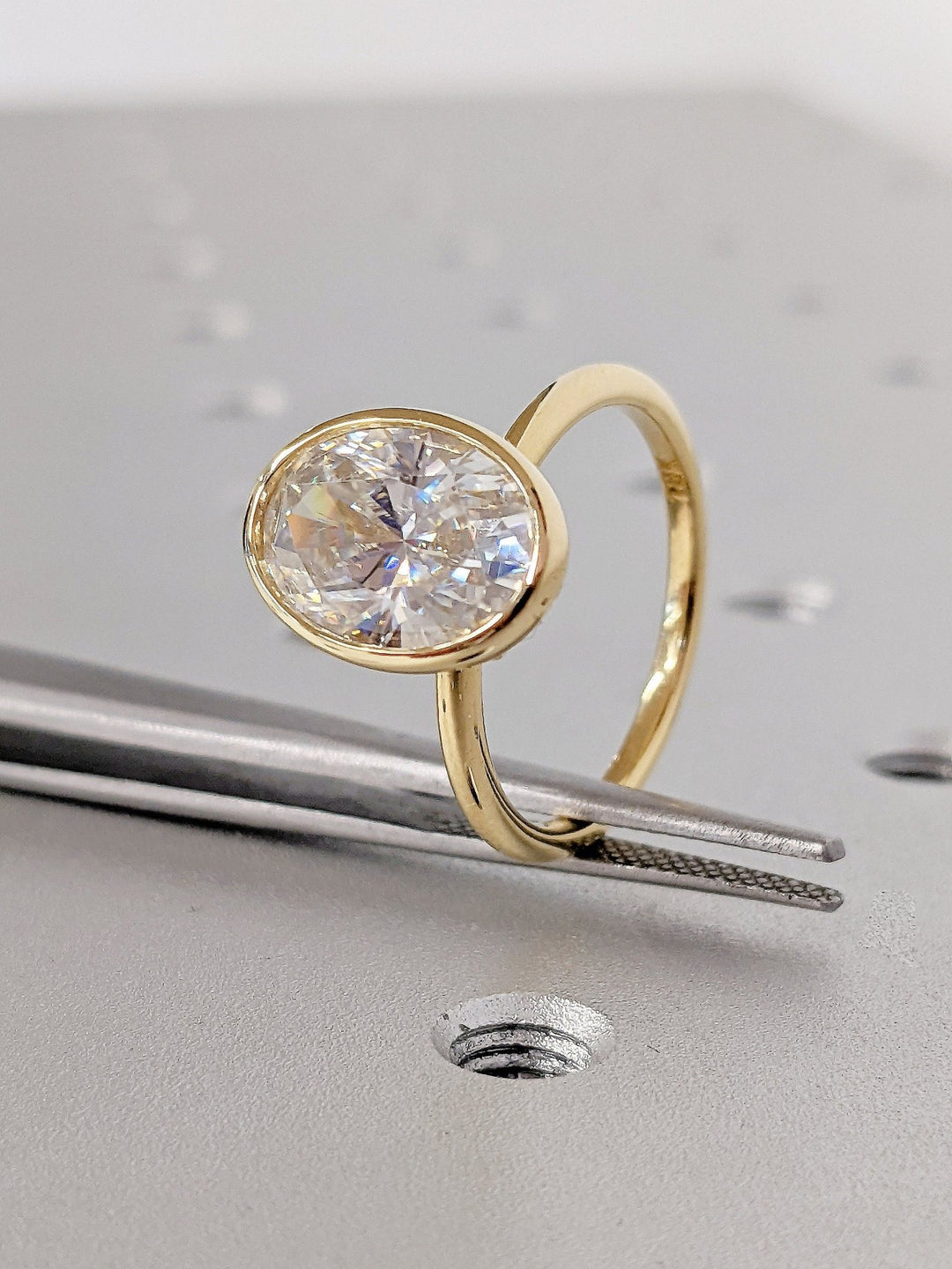IGI certified oval cut diamond in bezel engagement ring setting