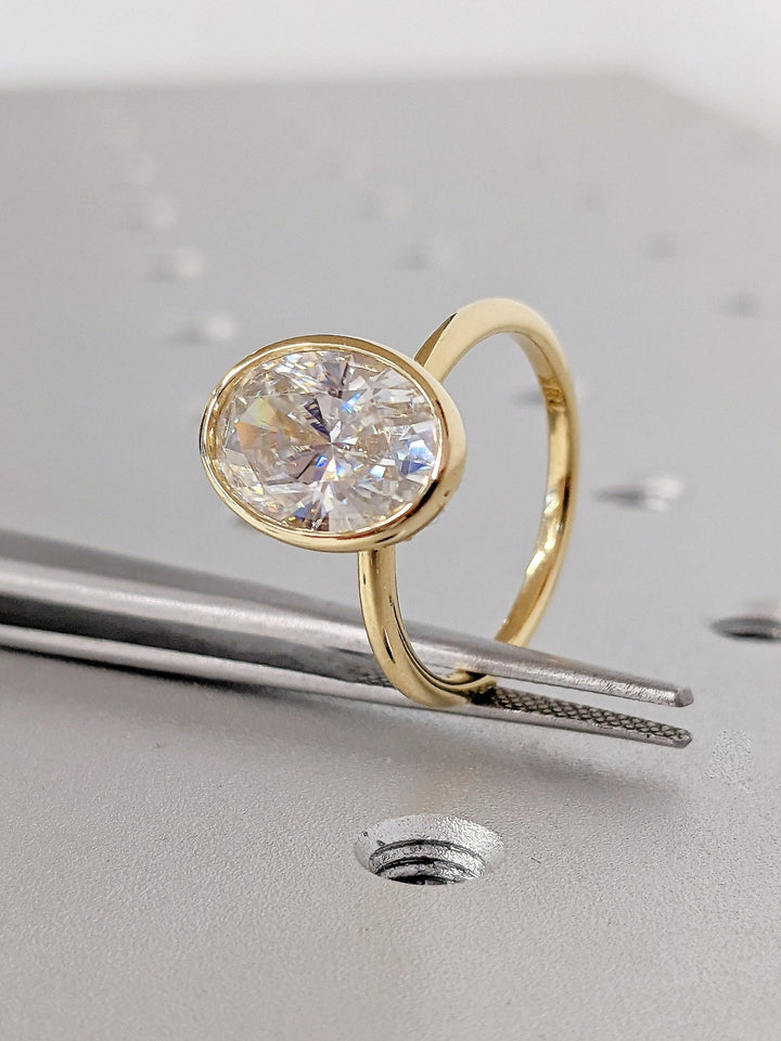IGI certified oval cut diamond in bezel engagement ring setting